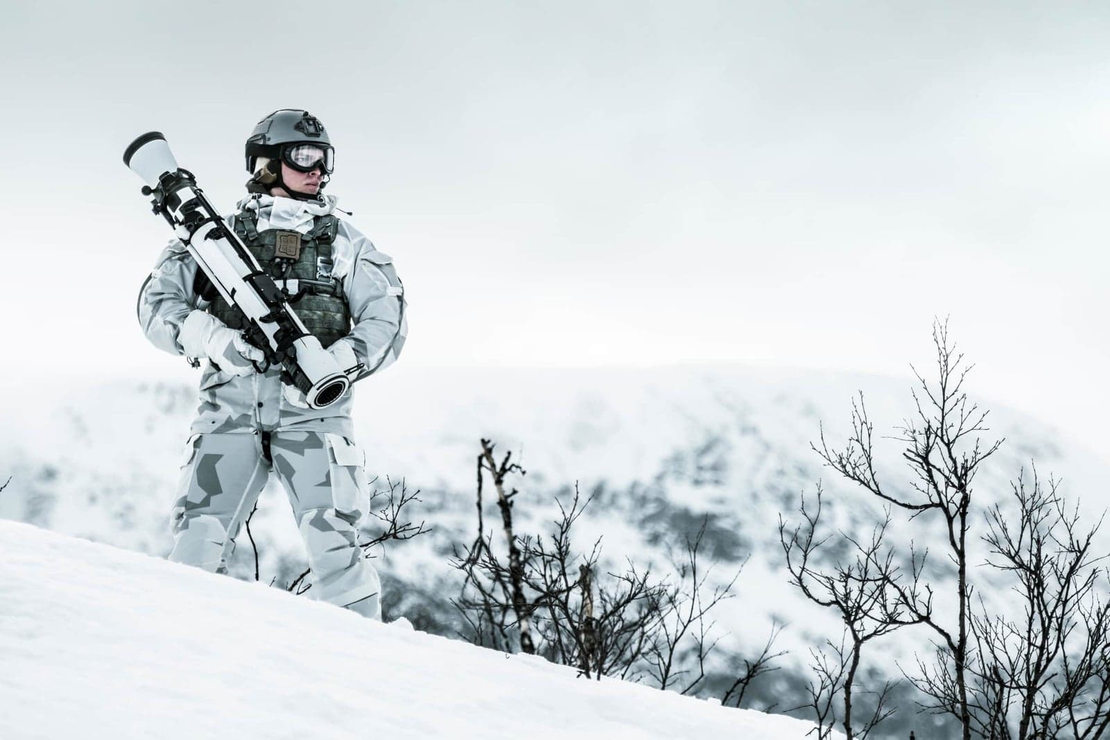 Soldier in winter camouflage carrying the Carl-Gustaf M4 across snow