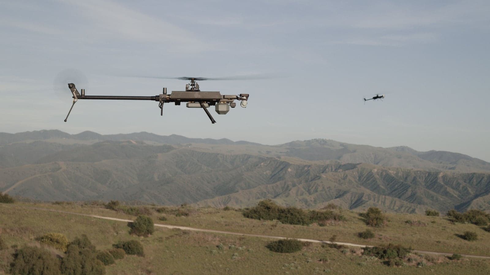 Ghost-X in flight over mountainous terrain at sunset