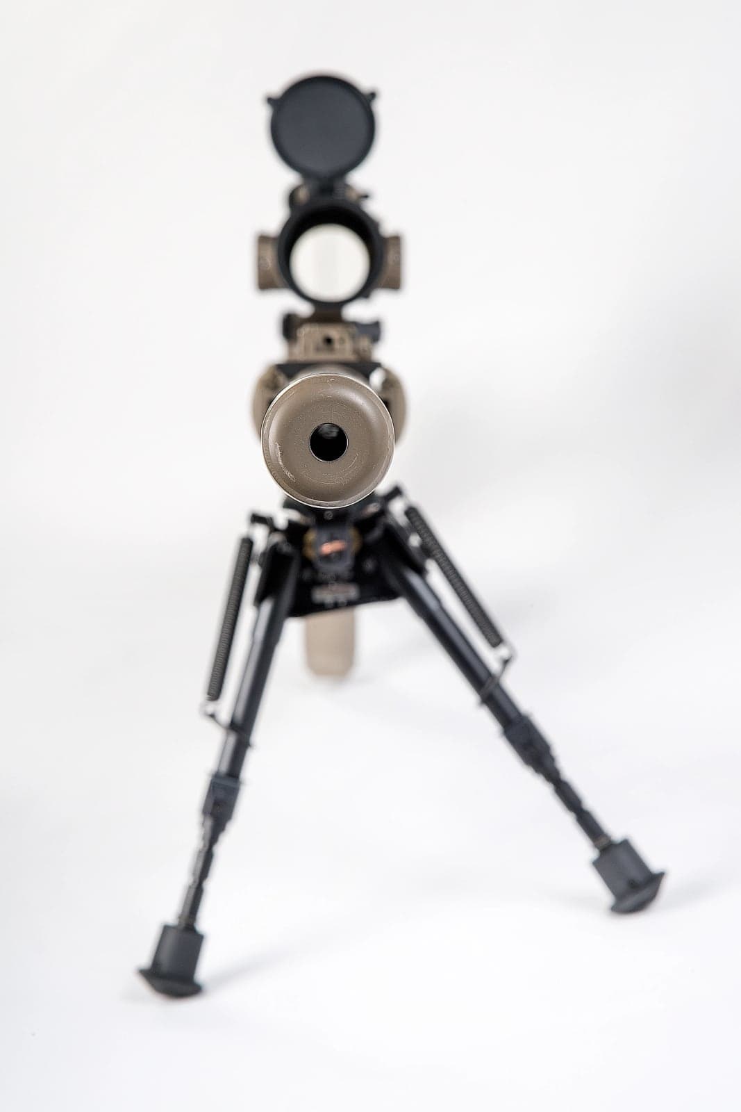 M110 rifle with suppressor attached, seen head-on from low in front of the bipod