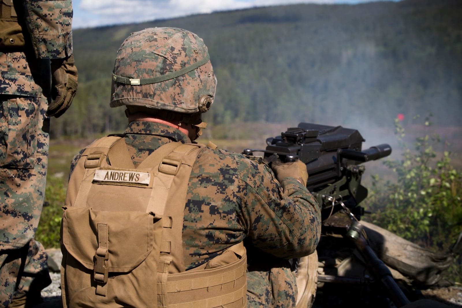 Marine firing a MK19 from a ground mount during a live-fire range in Norway