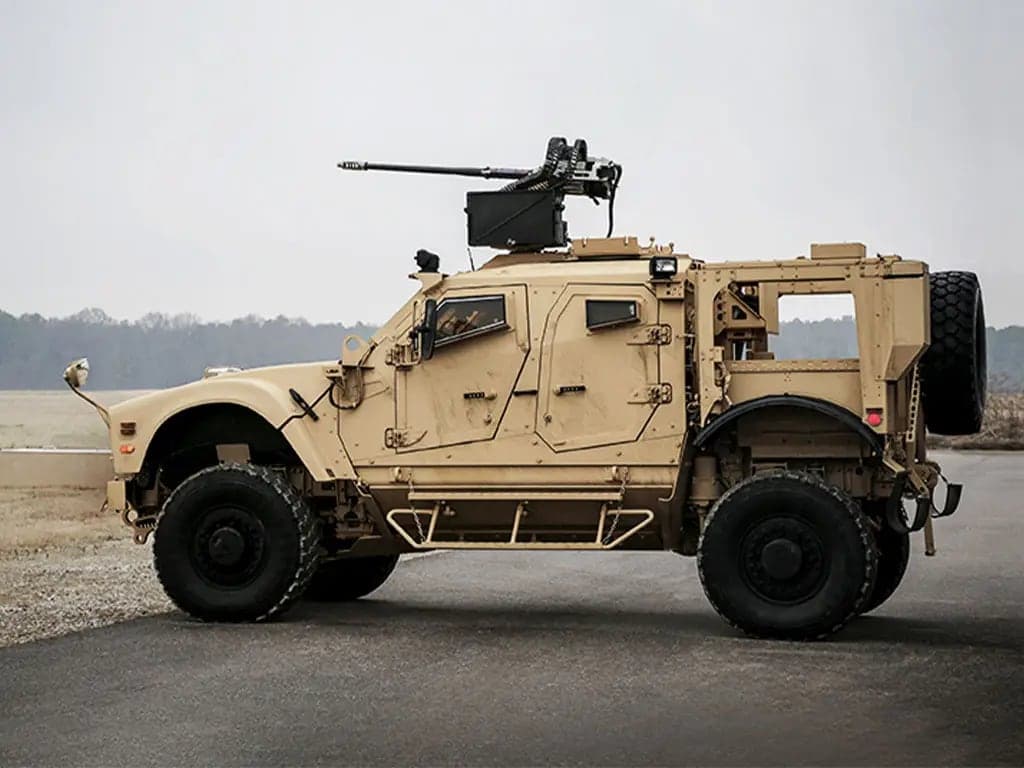 Tan M-ATV with a roof-mounted machine gun, side profile on a range