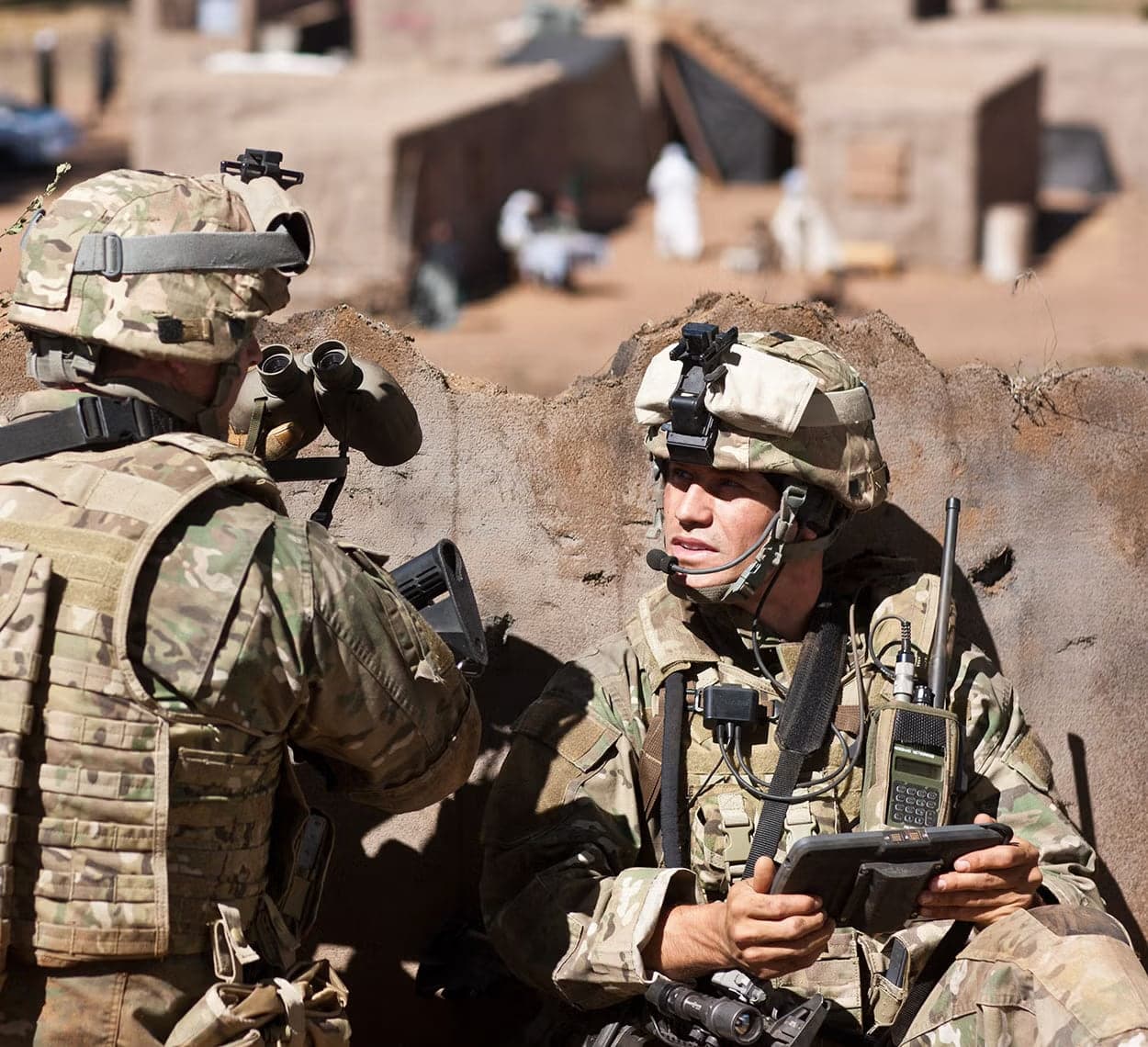 Soldiers in the field with a handheld radio and tablet