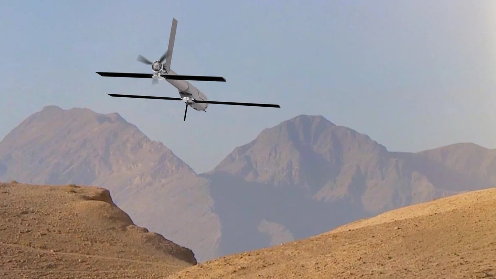 Switchblade 600 in flight with wings deployed over desert mountains