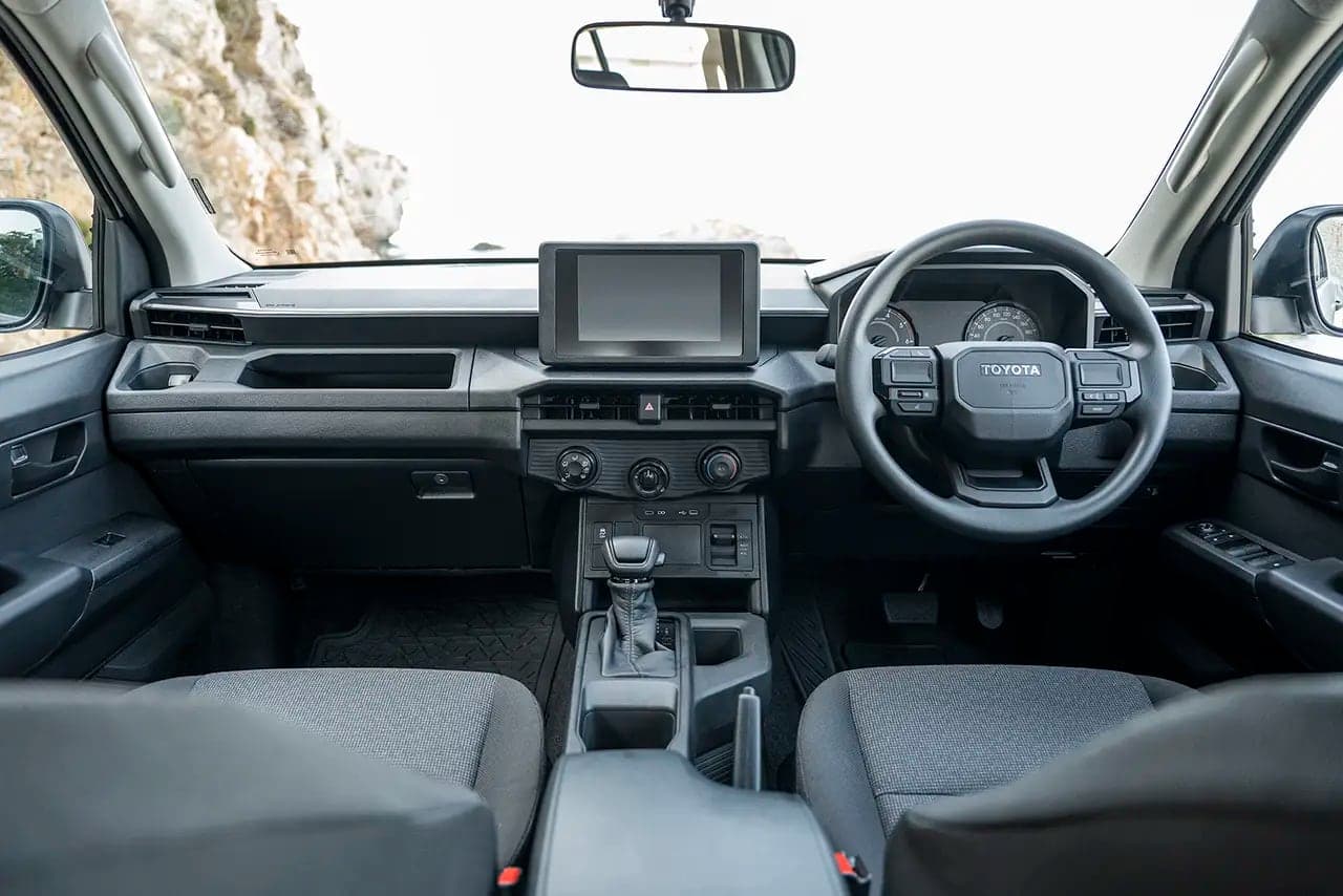 Hilux driver's cabin showing the steering wheel, digital display and dashboard