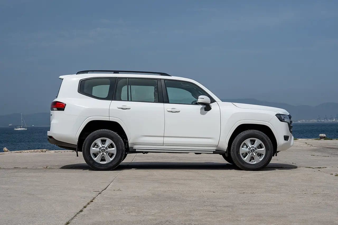 White Land Cruiser 300 in side profile on a waterfront quay