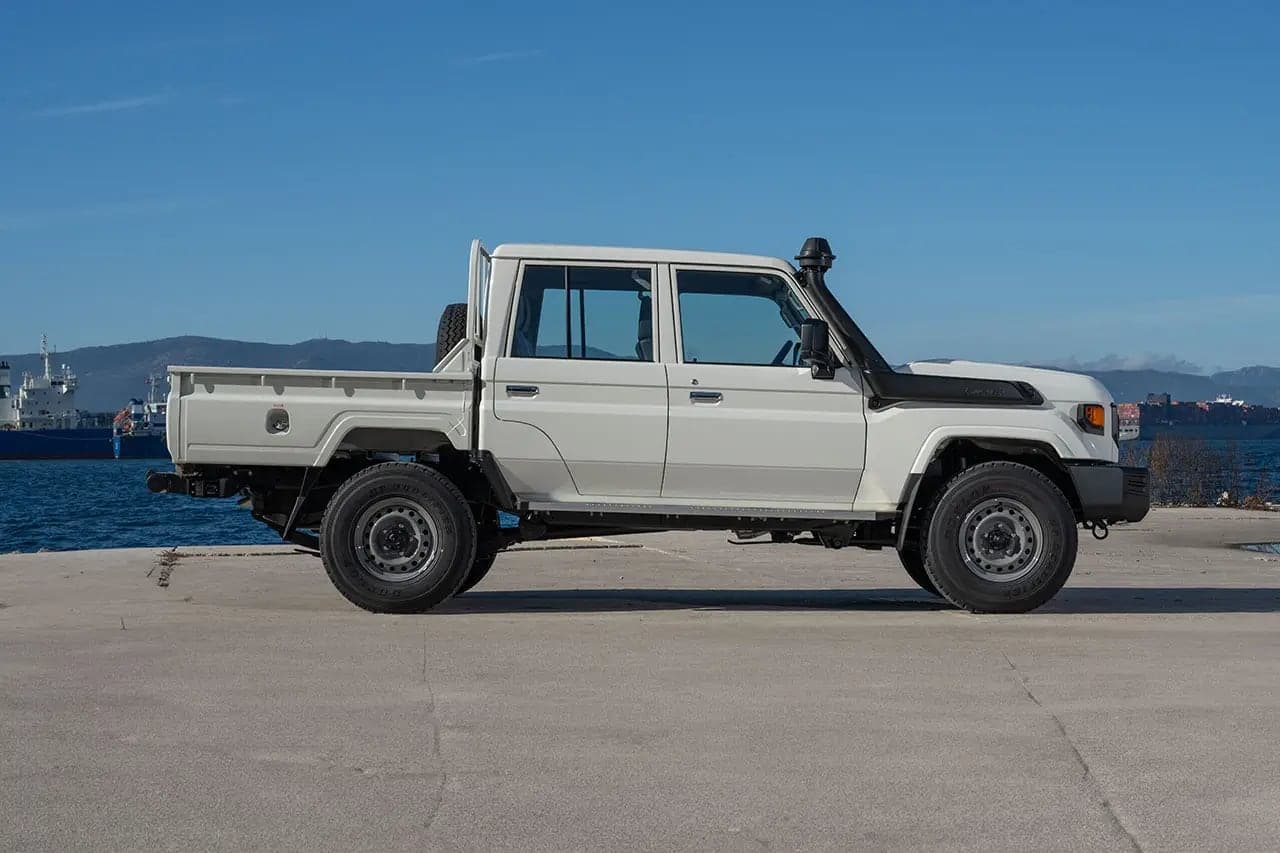 White Land Cruiser 79 Double Cab with snorkel, side profile on a quayside