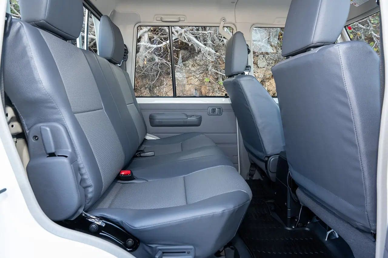 Grey vinyl front and rear bench seats inside the Land Cruiser 79 Double Cab